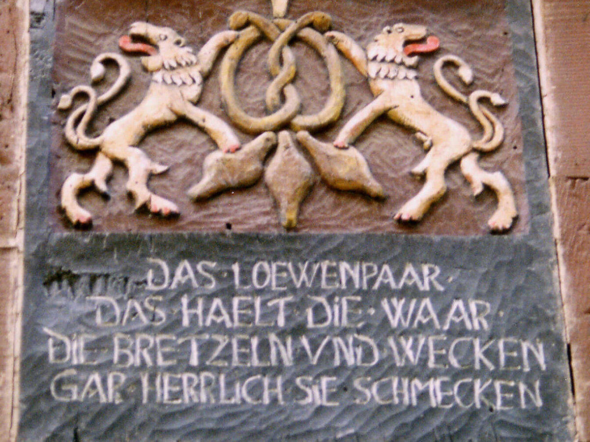 [Translate to Französisch:] Steinbild mit zwei Löwen, einem Brezel und einem Spruch