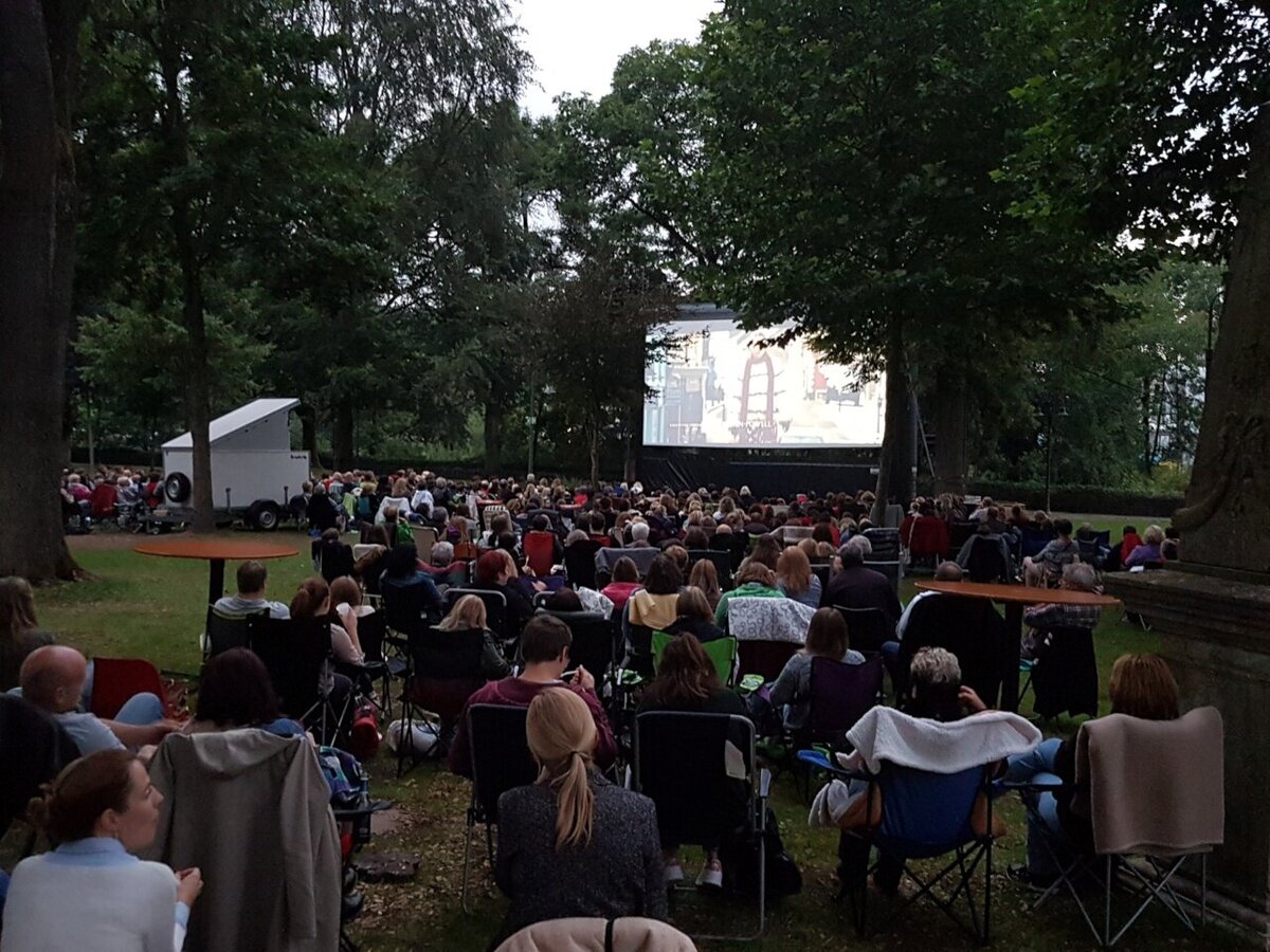 Menschen auf der Wiese beim Open Air Kino