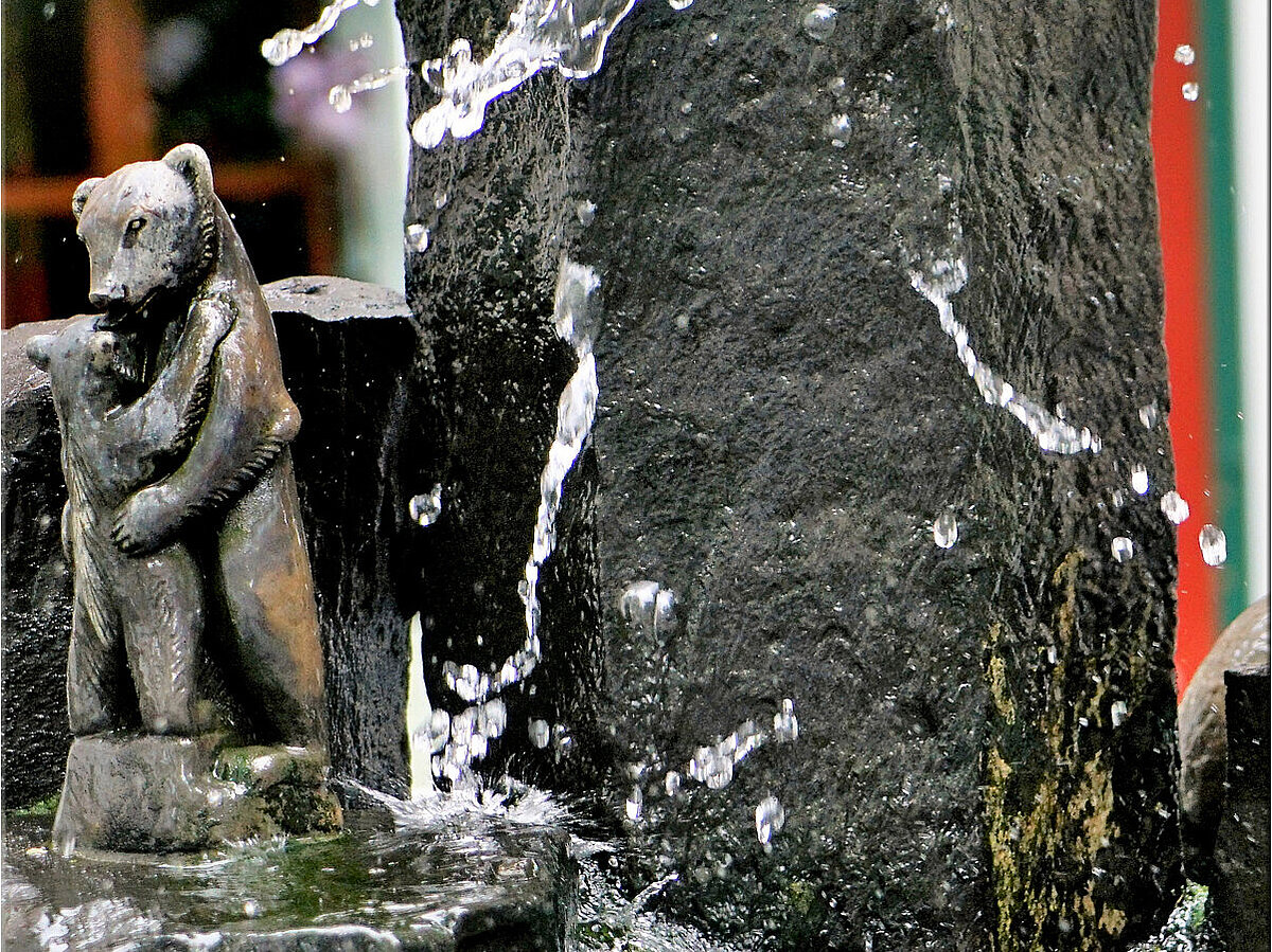 [Translate to Französisch:] Steinstatue von zwei Bären im Brunnen